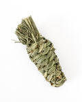 Dried timothy grass chew toy in shape of a carrot, photographed on a clean white background