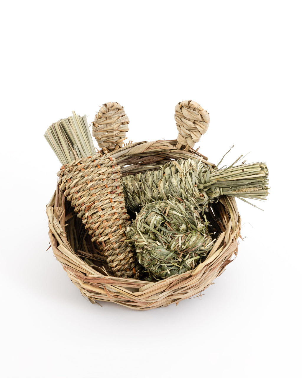 hand woven reed basket with bunny ears filled with a timothy grass ball, reed radish, and timothy grass carrot