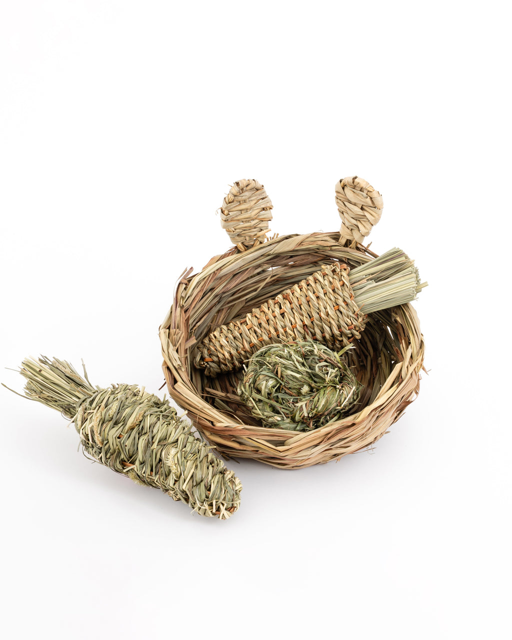 hand woven reed basket with bunny ears filled with a reed radish and a timothy grass ball. with timothy grass carrot on the side