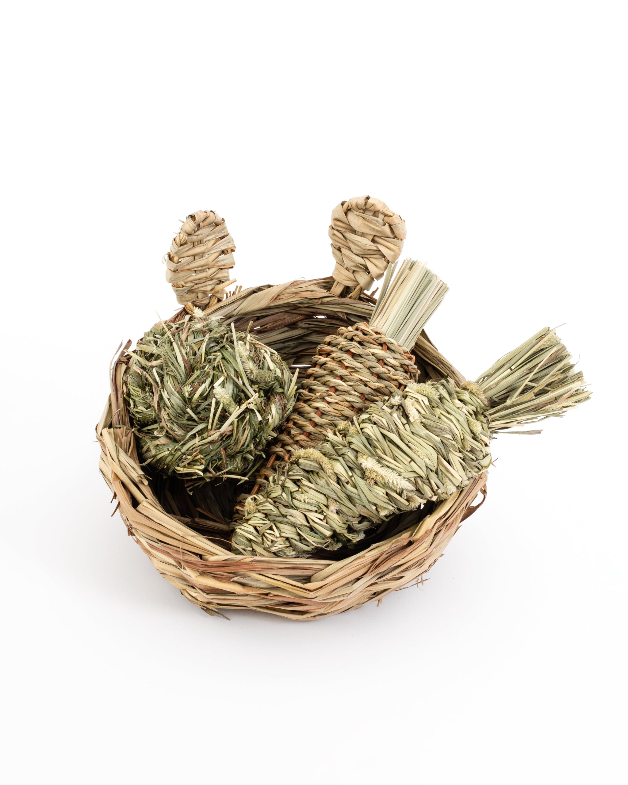 hand woven reed basket with bunny ears filled with a timothy grass ball, reed radish, and timothy grass carrot